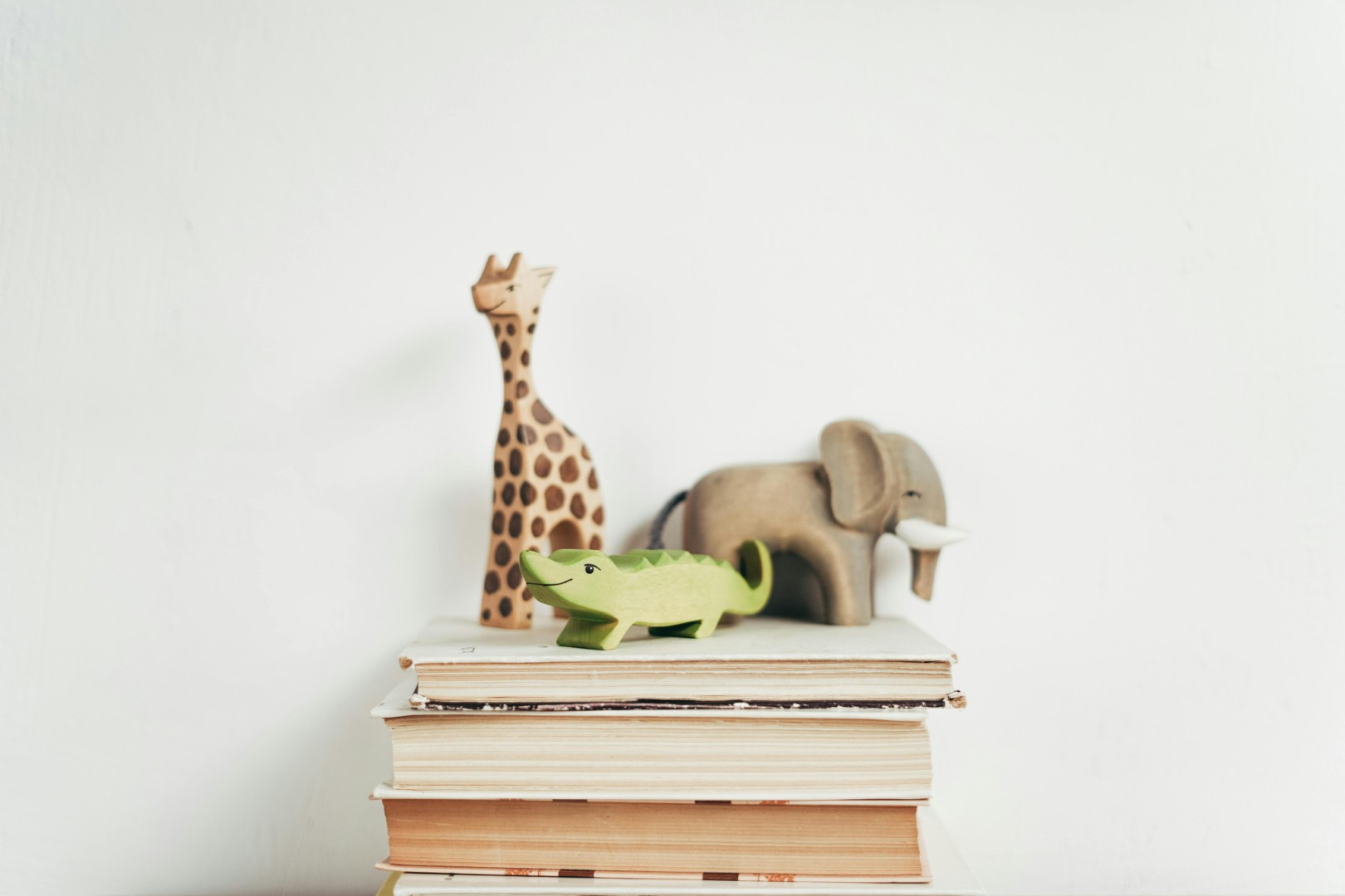 Wooden animals on top of a stack of books