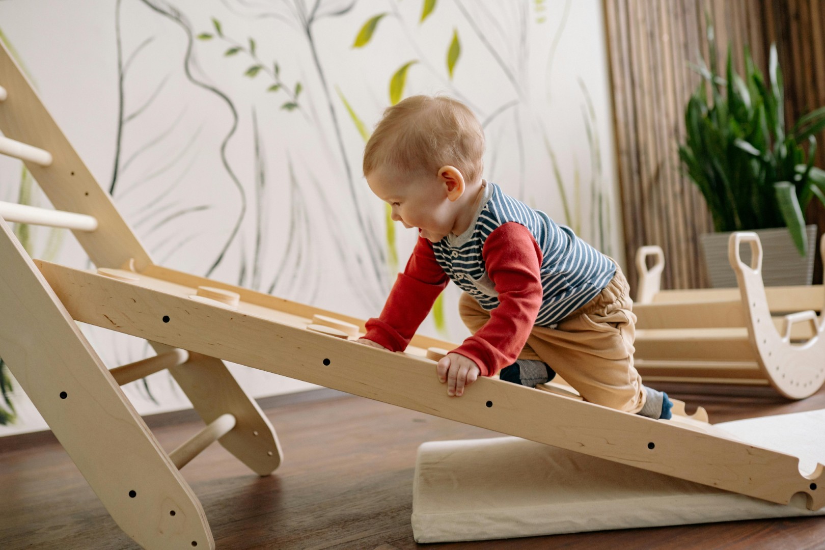 Infant climbing a wooden ramp
