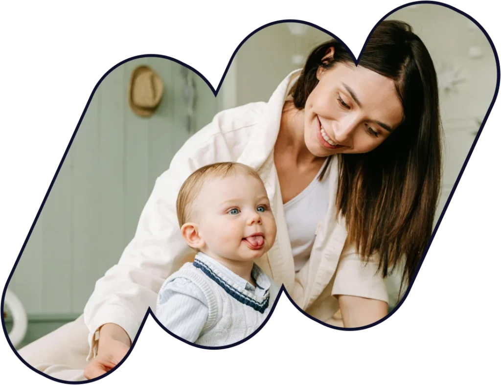 Smiling mother playing with her baby at home