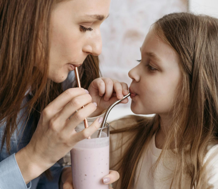 Woman and child drinking a smoothie